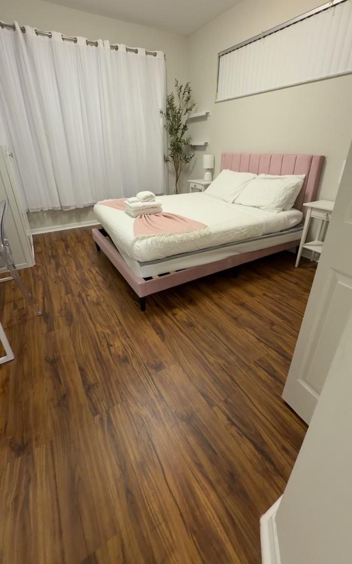 Neatly made bedroom with a pink headboard