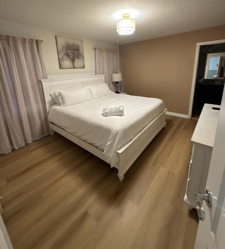 Guest bedroom, bed made and floors clean